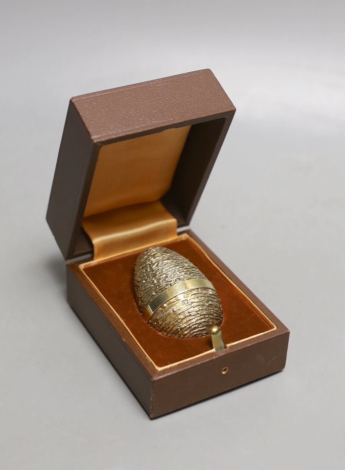 A cased modern silver gilt surprise egg, in the manner of Stuart Devlin, by Richard Lawrence Geere, London, 1976, 67mm, with bust interior.